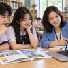 Hai học sinh trao đổi với người tư vấn khi tra cứu thông tin trường và ngành học trên máy tính, ảnh minh họa
